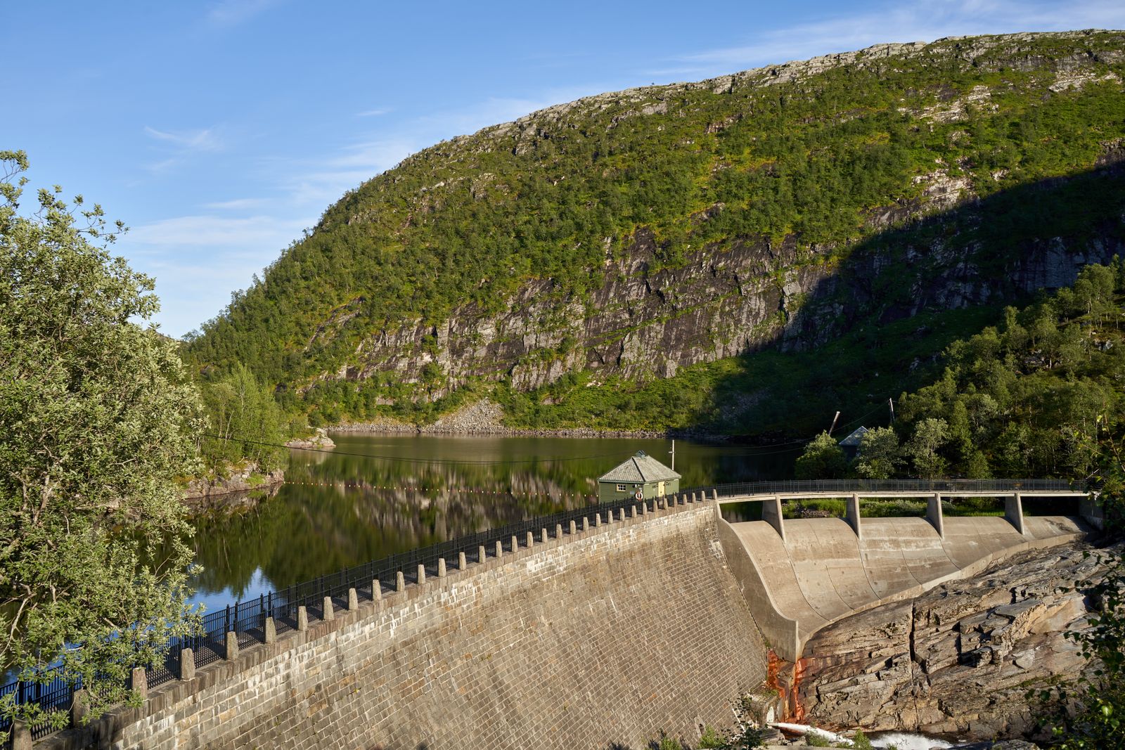 Masonry dam and reservoir in a green mountain valley