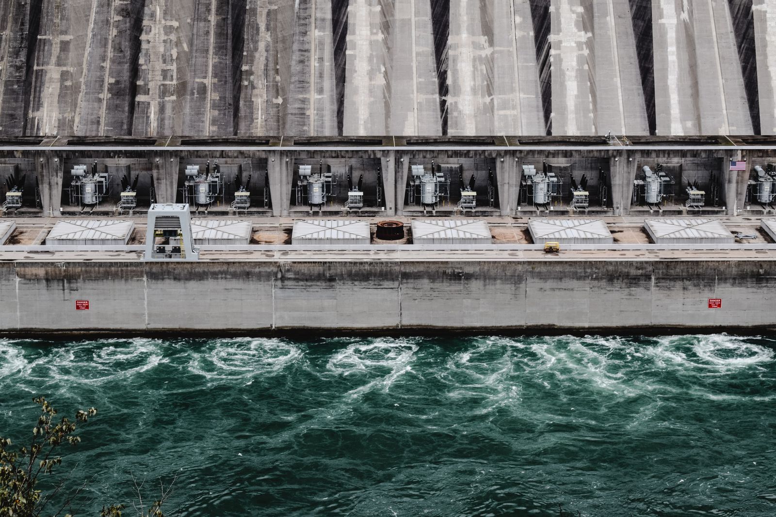 Hydropower dam wall with unit transformers and tailrace